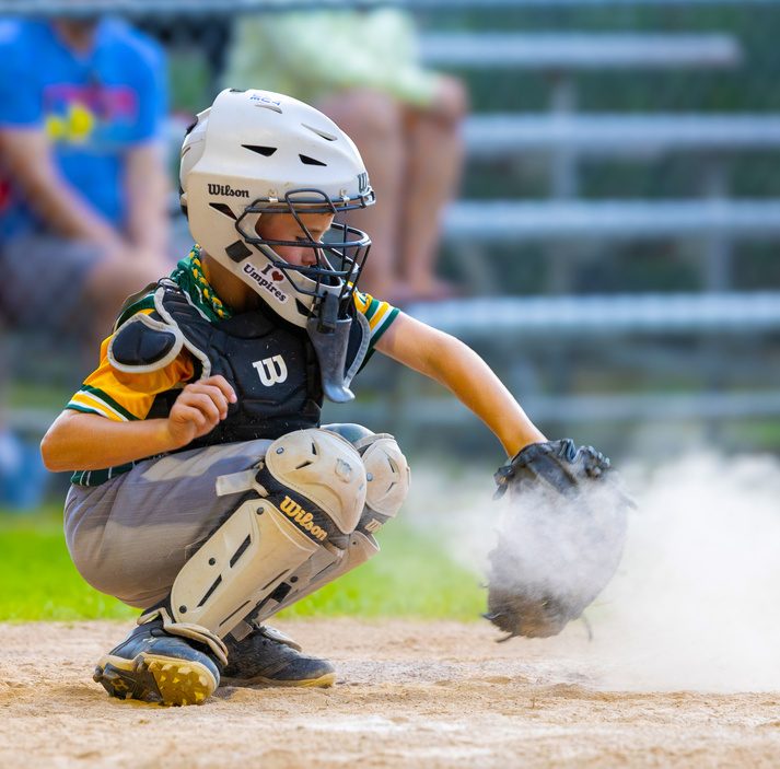 Catcher blocking a pitch in a cloud of dirt