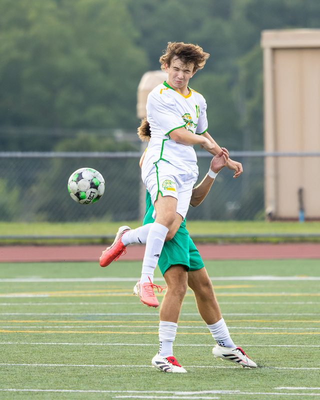High school soccer player striking the ball